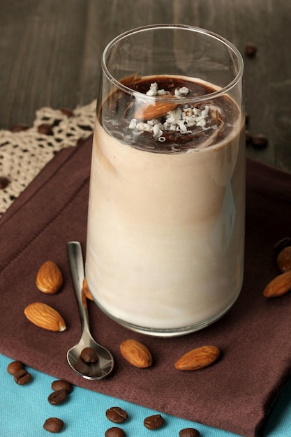 Un vaso de cóctel de crema de chocolate en un primer plano de mesa de madera