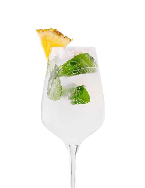 Vaso de cóctel que contiene refrescante cóctel de verano con piña y menta