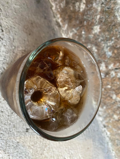 Un vaso de cola con cubitos de hielo