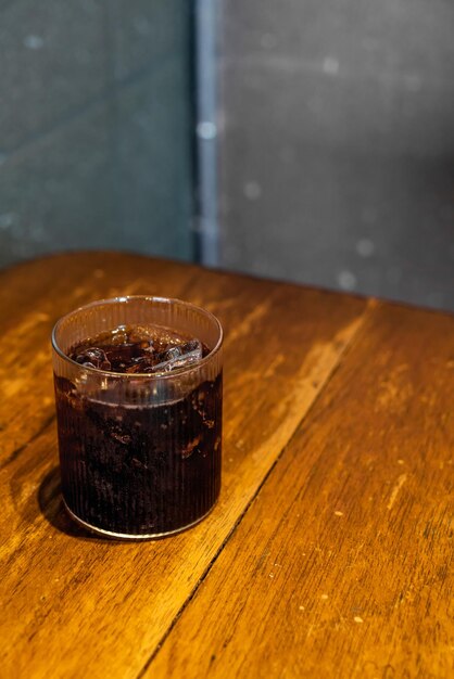 vaso de cola de hielo en la mesa de madera