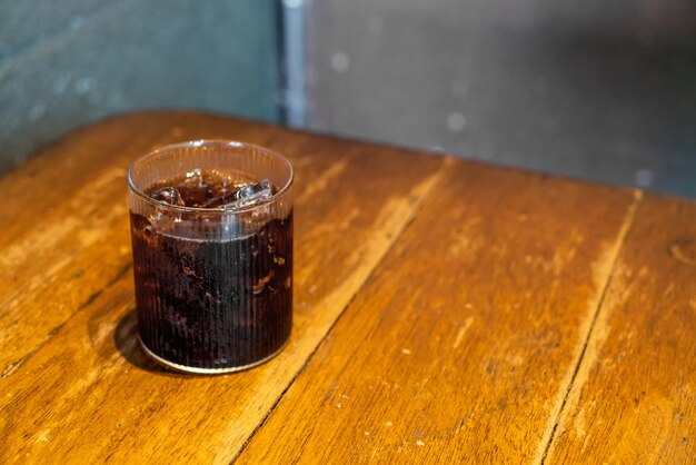 vaso de cola de hielo en la mesa de madera