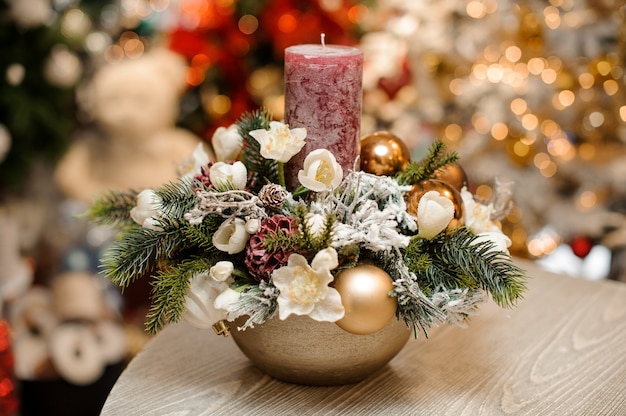 Vaso com decoração de Natal, composição de flores e velas