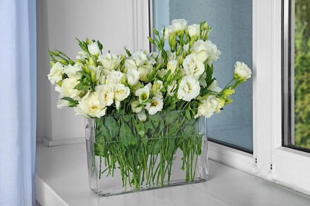 Vaso com lindas flores eustoma no peitoril da janela