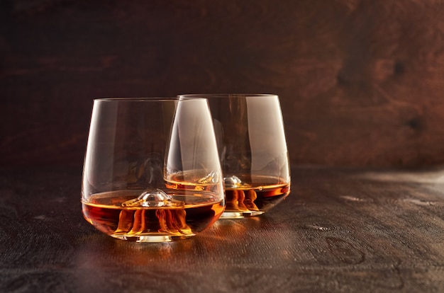 Vaso de cristal con whisky en una mesa de madera