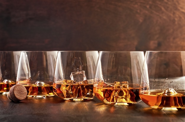 Vaso de cristal con whisky en una mesa de madera