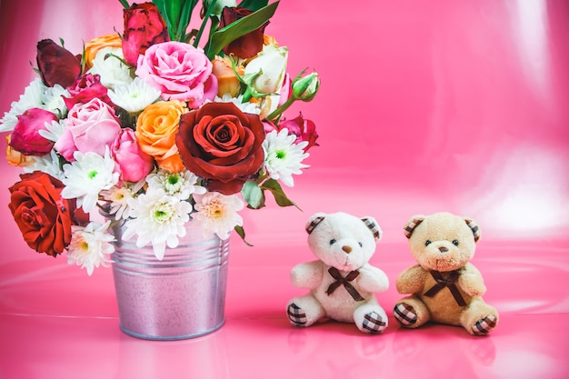 Vaso de buquê de rosas e lindo casal urso no fundo rosa