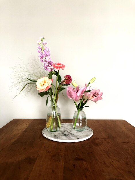 Foto vaso de flores na mesa contra a parede