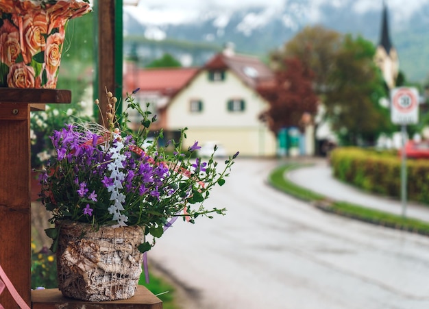 Vaso de pedra com flores roxas nas ruas da cidade de primavera Lindas flores em um vaso no terraço de um café Cidade turística com flores de rua