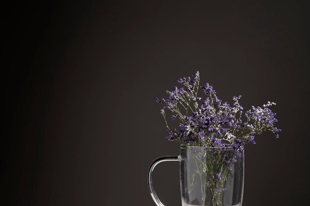 Vaso de vidro com flores lilás secas e copyspace