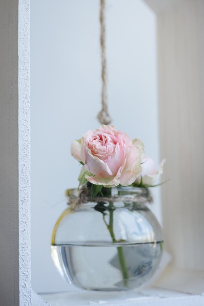 Vaso de vidro com pequena flor rosa em fundo cinza amarelo objeto antigo de decoração de interiores