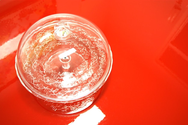 Vaso de vidro vazio em uma mesa vermelha