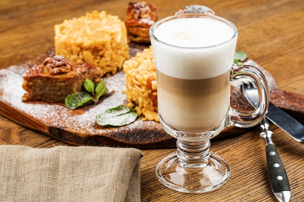 Un vaso de delicioso café con leche en la mesa de madera.