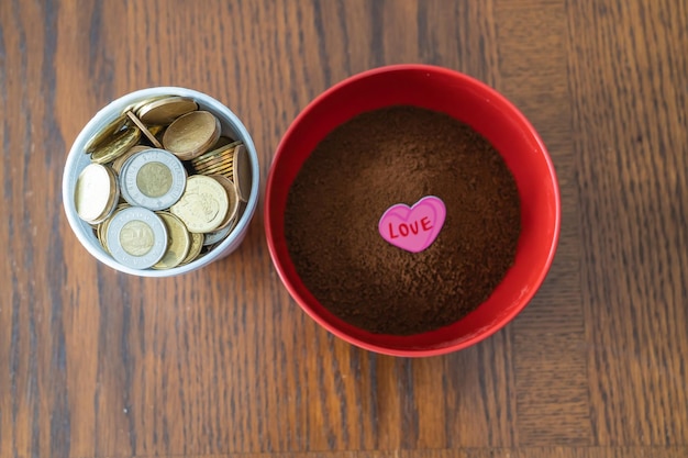 Vaso de espuma de poliestireno lleno de monedas con tazón rojo de café instantáneo