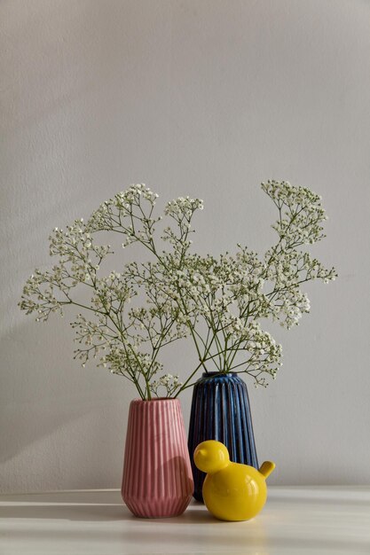 Vaso de flores en la mesa contra la pared