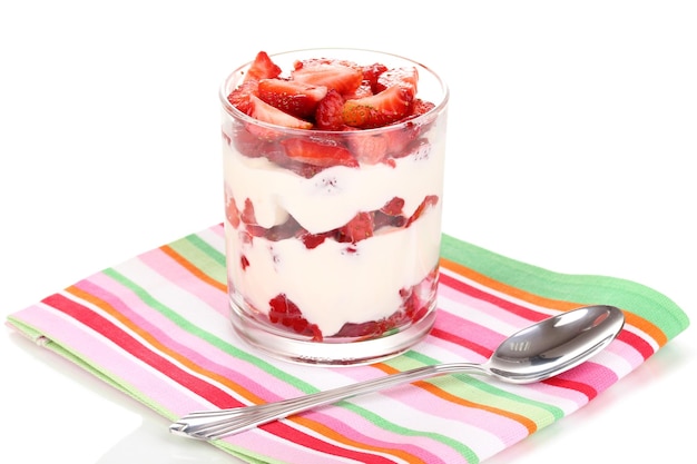 Vaso de fresas maduras con crema aislada en blanco