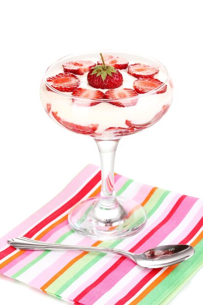 Vaso de fresas maduras con crema aislado en blanco