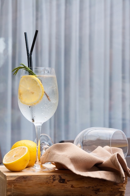 Un vaso de gin tonic con limón en un restaurante.