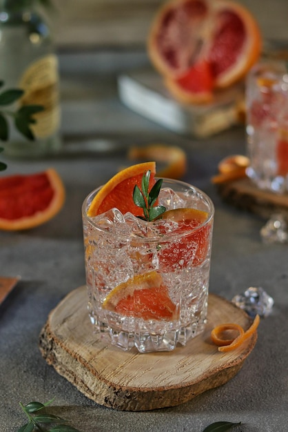 Un vaso de ginebra de pomelo con una ramita de romero encima.