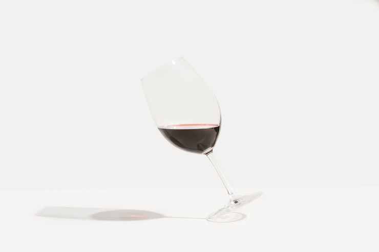 Un vaso inclinado de vino tinto
