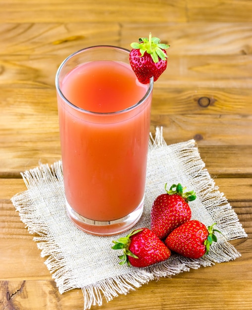 Vaso de jugo de fresa con fresas frescas