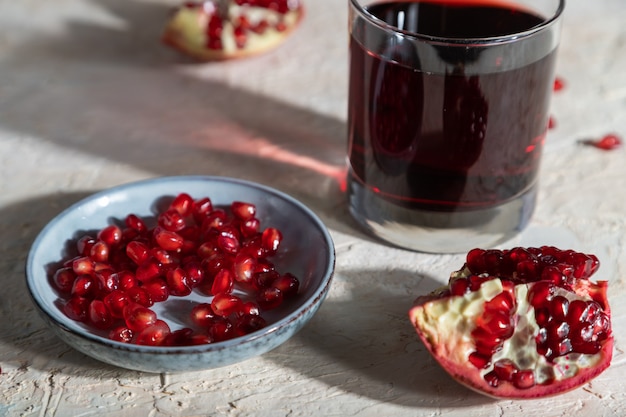 Vaso de jugo de granada y fruta de granada