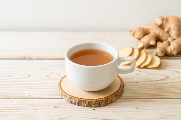 Vaso de jugo de jengibre fresco y caliente con raíces de jengibre - Estilo de bebida saludable