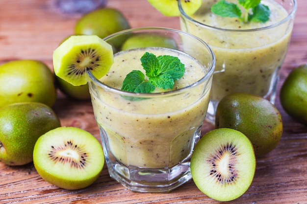 vaso de jugo de kiwi con frutas frescas en la mesa de madera