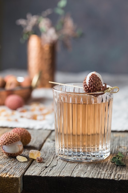 Vaso de jugo de lichi frío sobre la mesa de madera antigua, estilo rústico