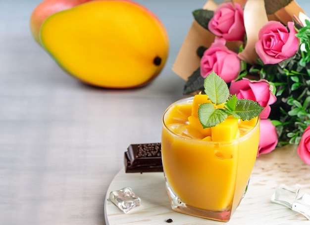 Un vaso de jugo de mango en verano con hojas de menta