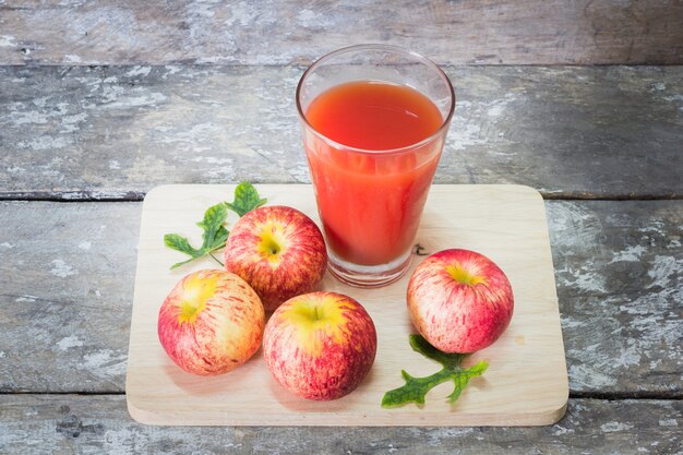 Vaso de jugo de manzana en la mesa de madera oscura