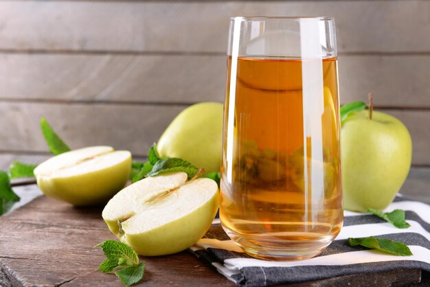 Vaso de jugo de manzana sobre fondo de madera