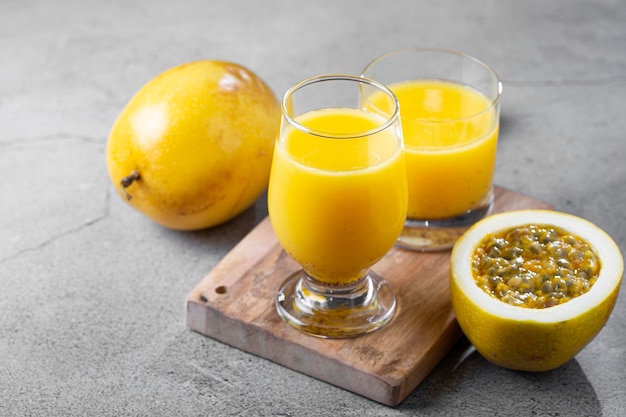 Foto vaso con jugo de maracuyá y maracuyá en rodajas sobre la mesa