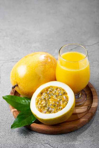 Vaso con jugo de maracuyá y maracuyá en rodajas sobre la mesa