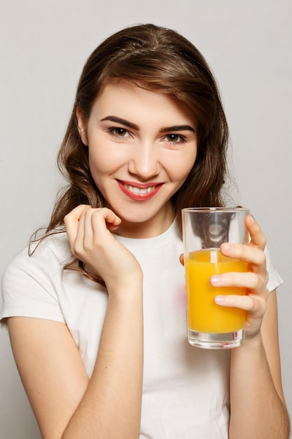 Vaso de jugo de mujer. Modelo femenino mantenga vaso de jugo de naranja