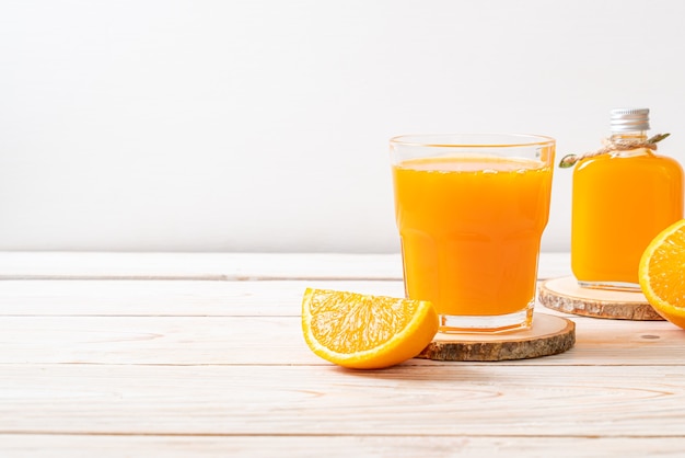 Vaso de jugo de naranja fresco sobre fondo de madera