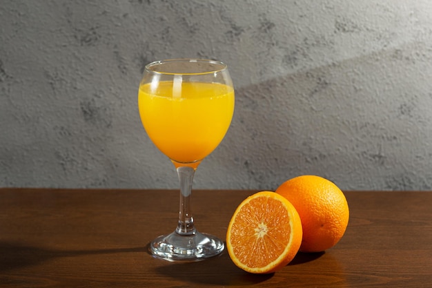 Foto un vaso de jugo de naranja junto a un vaso de jugo de naranja.