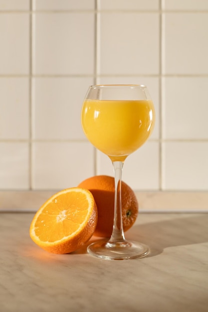 Un vaso de jugo de naranja a la luz de la mañana en la encimera de la cocina