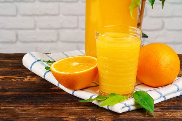 Vaso de jugo de naranja en la mesa de madera de cerca