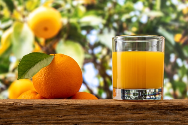 Vaso de jugo de naranja en la mesa de madera