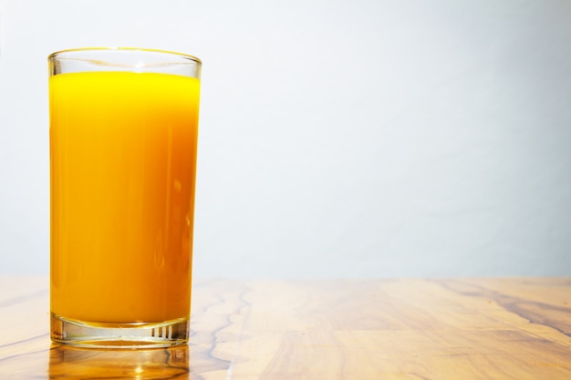 Vaso de jugo de naranja en la mesa de madera