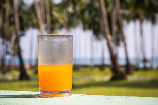 Vaso de jugo de naranja en una mesa de playa