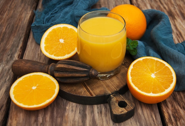 Un vaso de jugo de naranja y naranjas frescas