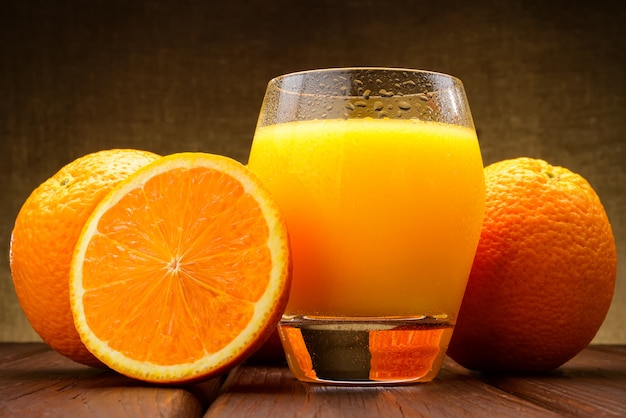 Vaso de jugo de naranja y naranjas