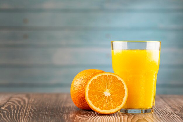 Vaso con jugo de naranja sobre la mesa.