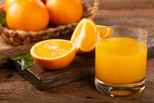 Vaso con jugo de naranja sobre la mesa.