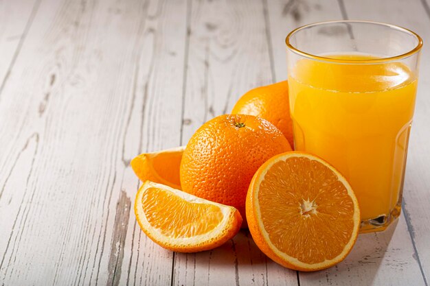 Vaso con jugo de naranja sobre la mesa.