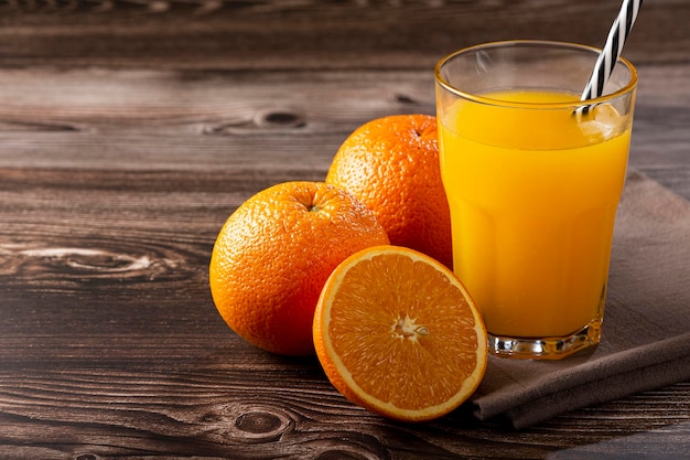 Vaso con jugo de naranja sobre la mesa.