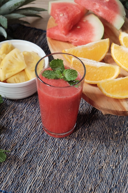 Vaso de jugo de sandía y rodaja de algunas frutas