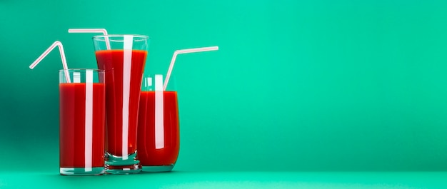 Vaso de jugo de tomate aislado en fondo verde con espacio de copia