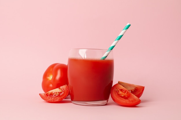 Vaso con jugo de tomate fresco en rosa